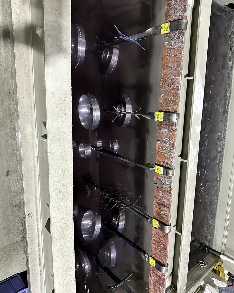 Aluminum parts hanging in an anodizing tank