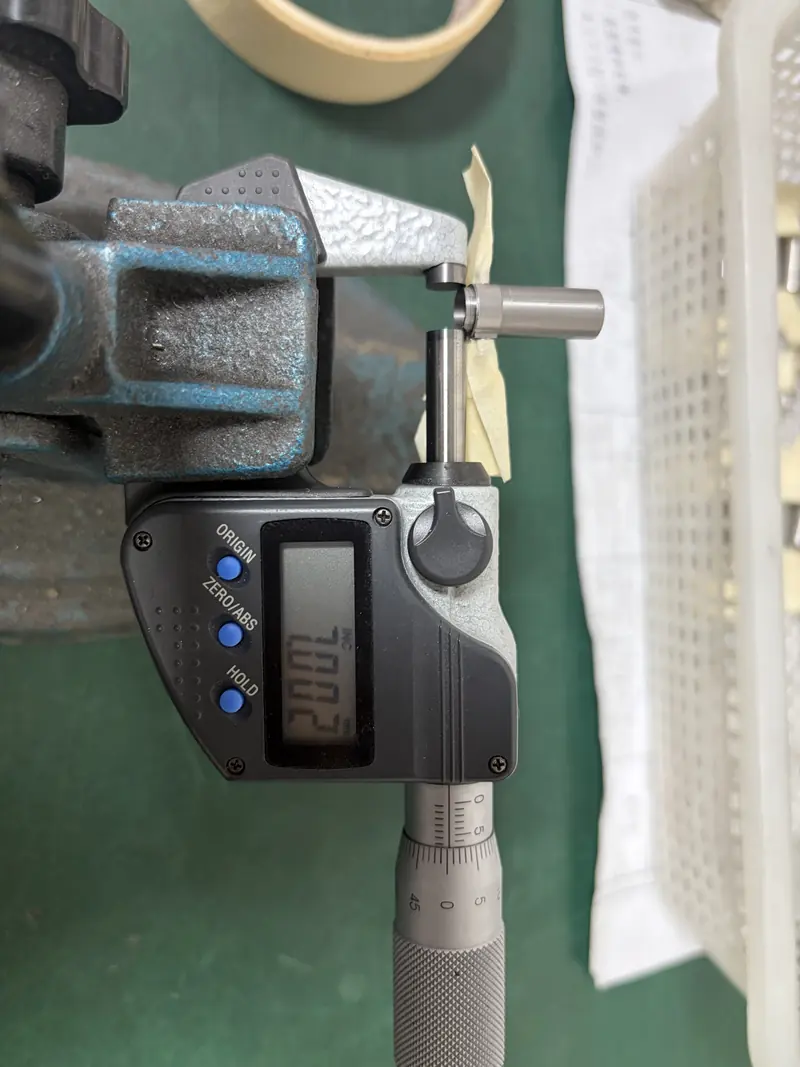 Digital micrometer reading 7.002 mm on the Ø7 step of a motor housing