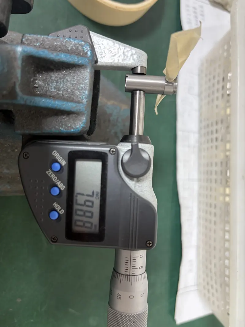 Digital micrometer reading 7.988 mm on the Ø8 diameter of a motor housing