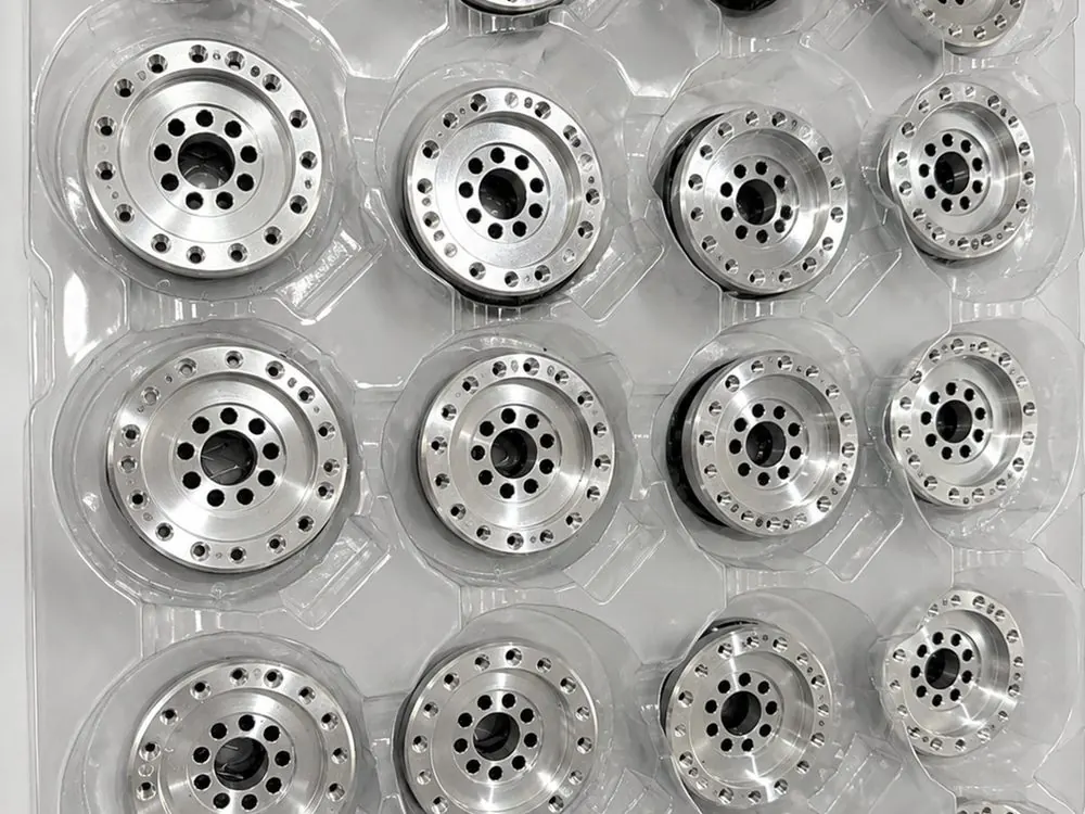 Batch of machined aluminum flanges packed in a formed tray