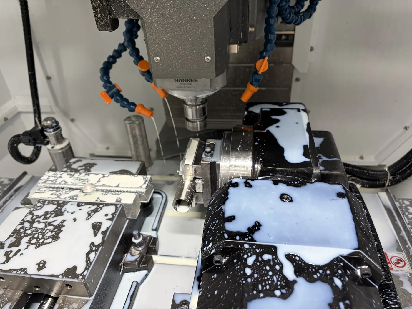 Machining center milling an aluminum part under coolant at Meili Machining