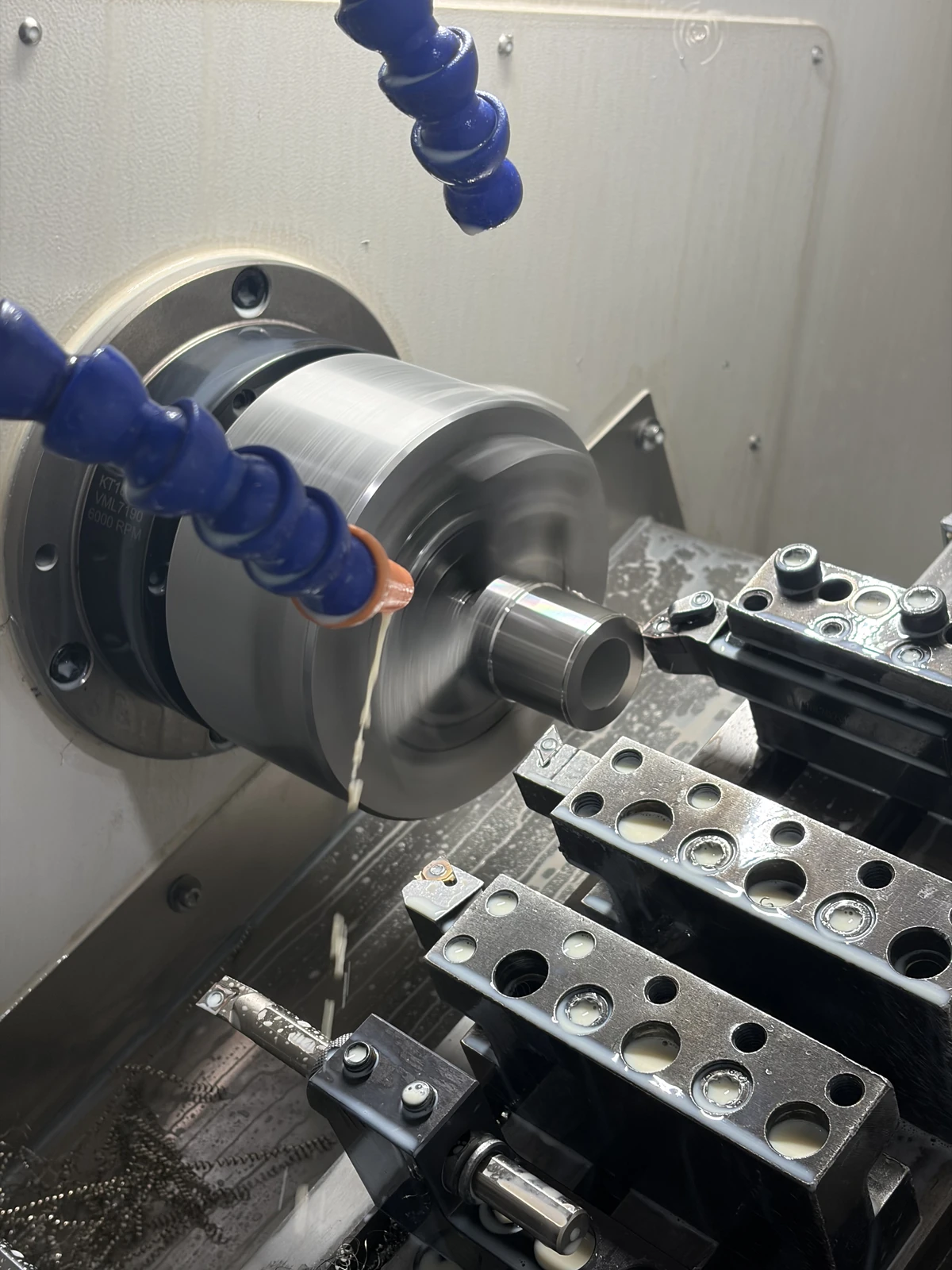 CNC turning operation with live tooling and coolant delivery inside a lathe