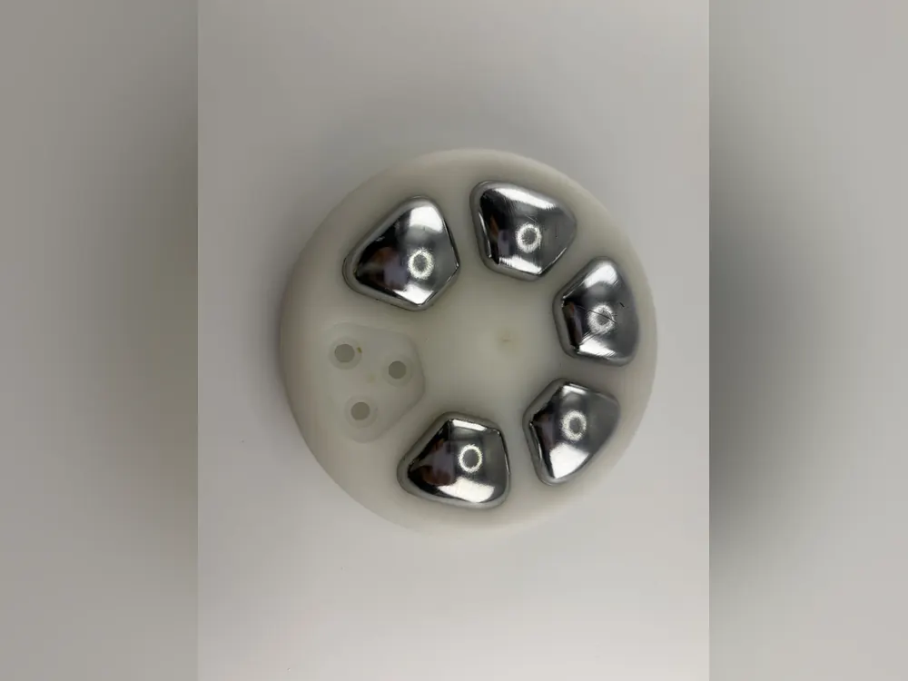 Electropolished stainless steel features set in a white plastic carrier, a non-implant medical part
