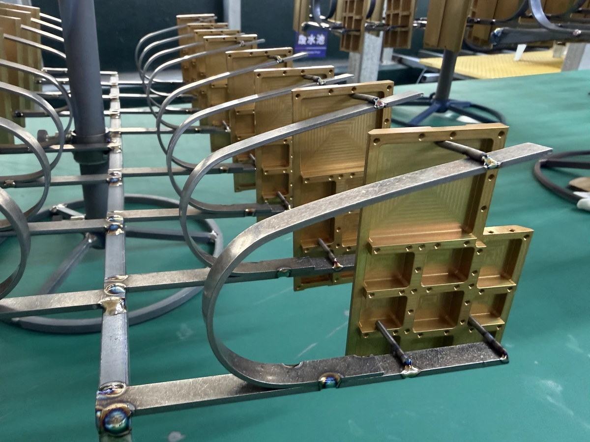 Brass machined parts arranged on a surface finishing rack