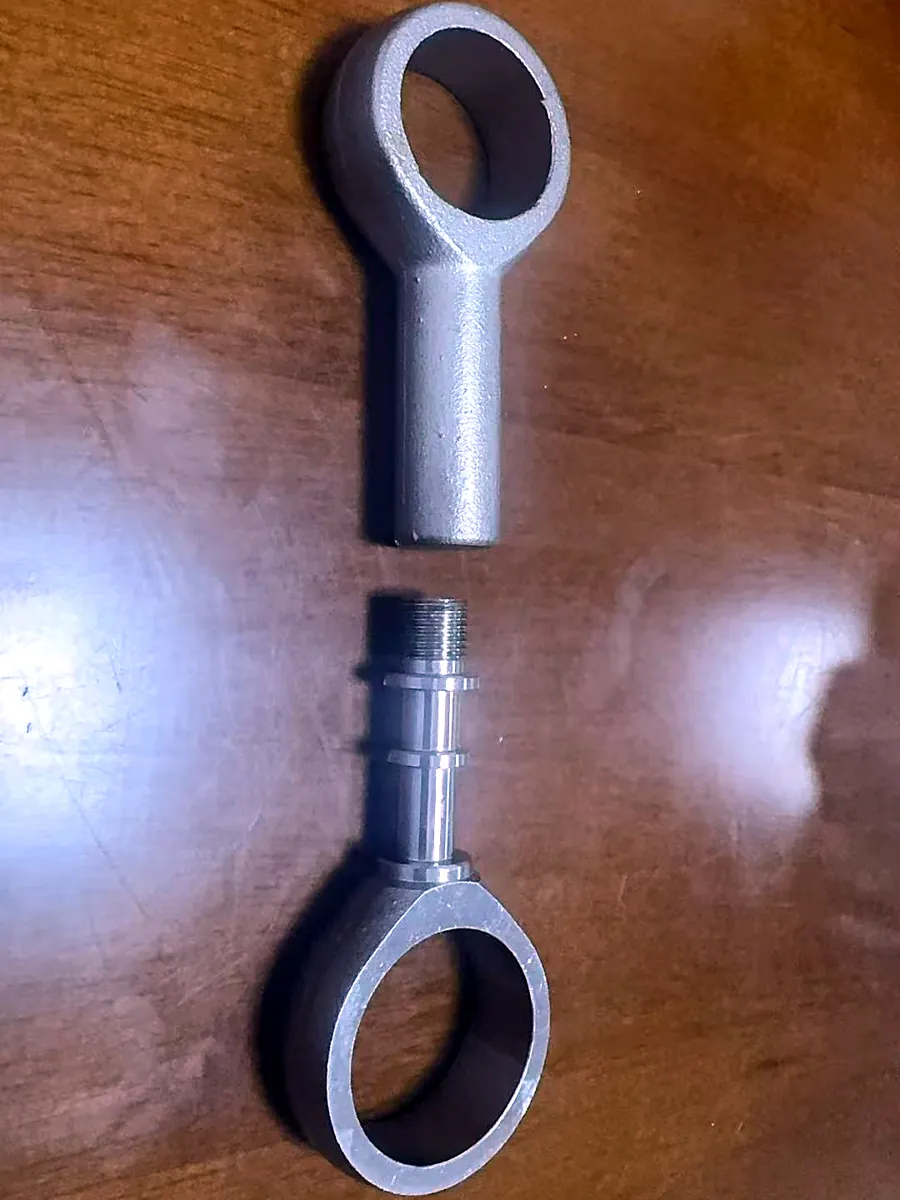 Investment-cast duplex stainless blank above a machined part with turned stem and thread