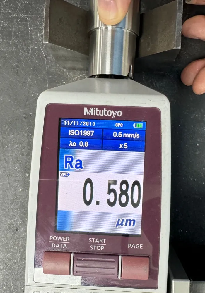 Mitutoyo SJ-210 roughness tester on a machined shaft reading Ra 0.580 micrometres